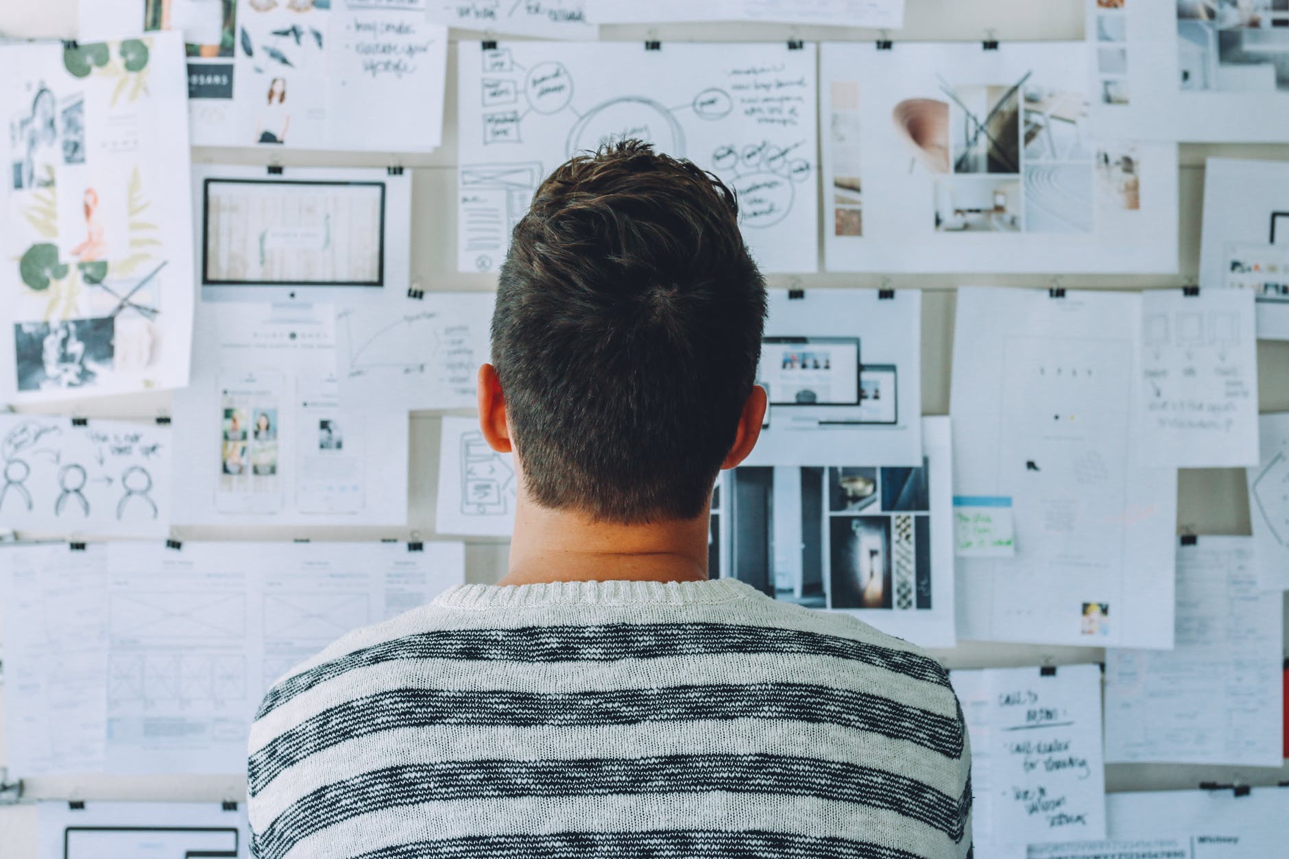 Person looking at a wall with different documents