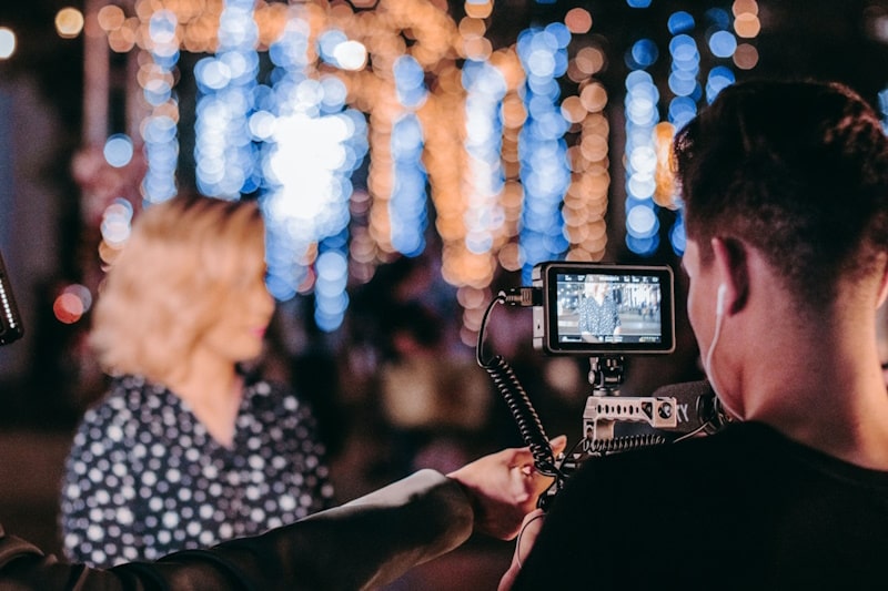 Video camera hold by a man filming a woman