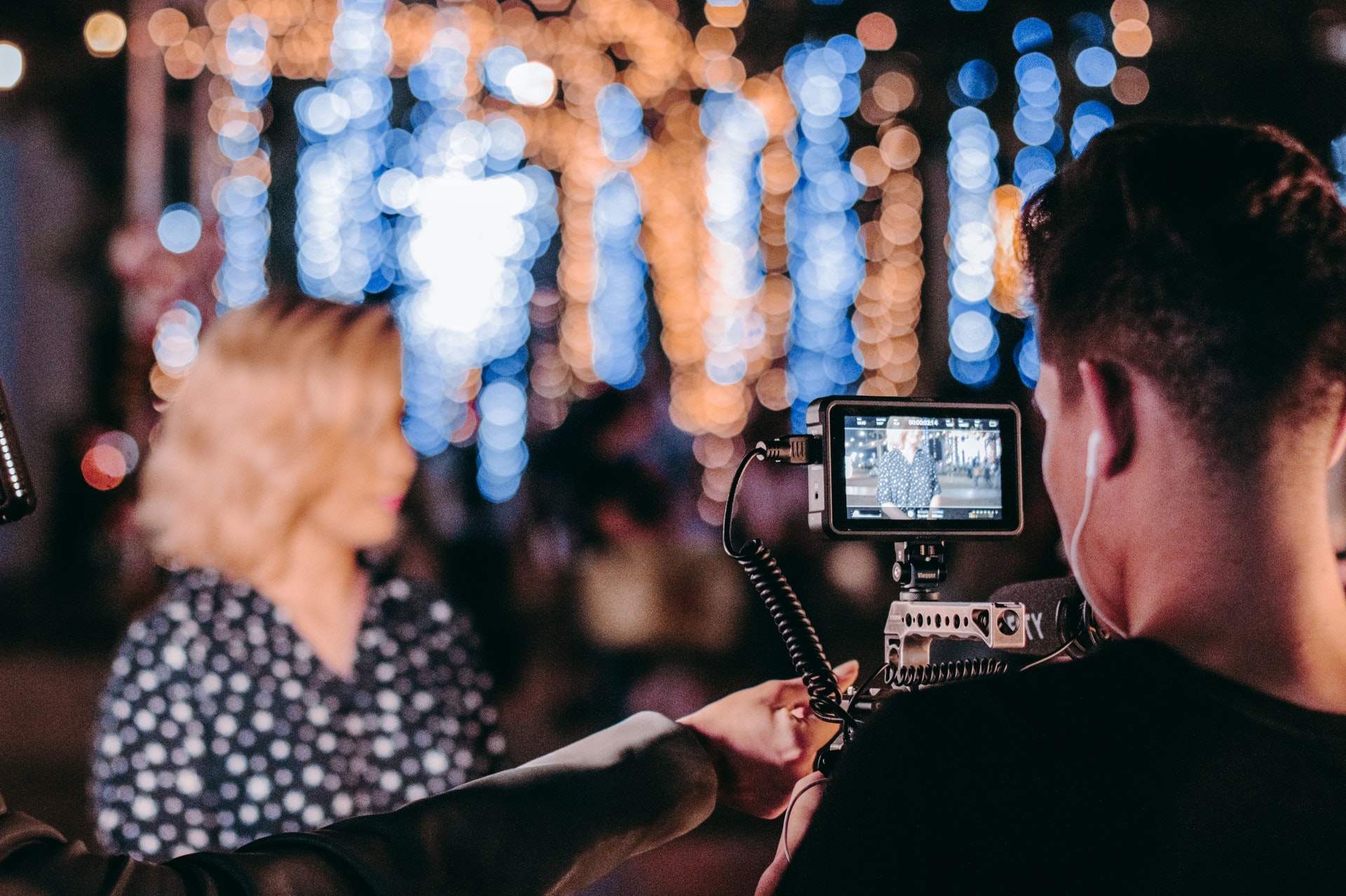 Video camera hold by a man filming a woman